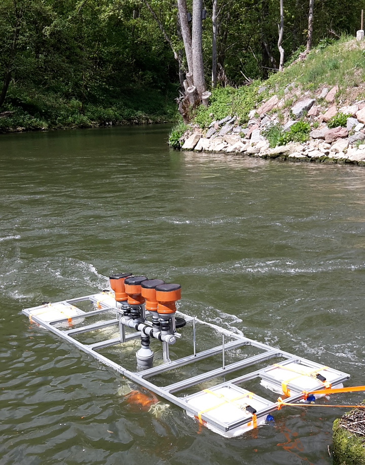 Field test with DEGREEN generators in a watercourse. The excitation of the silicone membranes takes place via the negative pressure in the Venturi tubes under the raft through which the water flows.